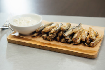 sprat with sauce on a cutting board on the table