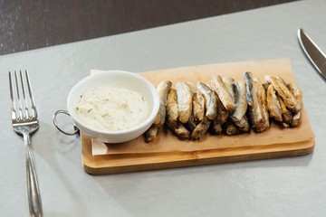 sprat with sauce on a cutting board on the table