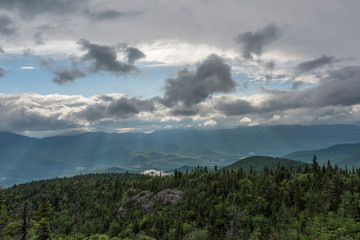 dark storm clouds and sun rays protruding from the cracks of weather