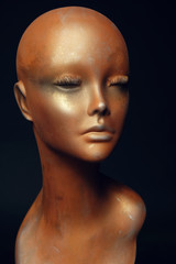 Closeup studio shot of colored woman mannequin with stylish decoration, dark background