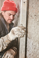 Real construction worker making a wall inside the new house.