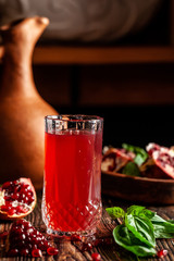 The concept of Georgian and Armenian cuisine. Cool drink with ice of basil and pomegranate juice in a glass goblet. Background image. copy space