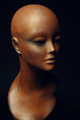 Closeup studio shot of colored woman mannequin with stylish decoration, dark background