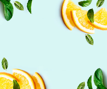 Citrus Slices And Mint Herbs Frame On Retro Mint Pastel Background With Copyspace From Above. Top View Of Lemon And Orange Refreshment.