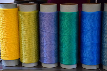 Five bobbins with polypropylene thread, front view. Large colorful technical thread set in rainbow mood. Multicolor bobbin thread. Polypropylene multifilament yarns.
