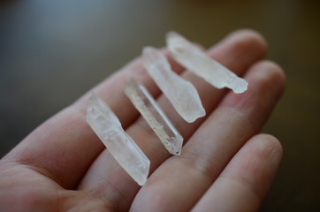 Clear Quartz points being held in woman's hand. Healing quartz points, bright colors. Healing crystals being held, reiki energy healing. Natural lighting photo with macro lens, photo of clear quartz.