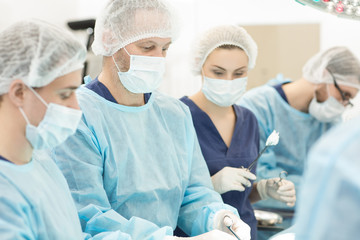 Team of surgeons performing surgery in operation room