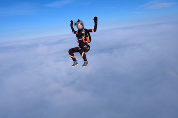 Fototapeta na wymiar Skydiving. Pretty girl is sitting above white clouds.
