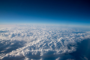 Fototapeta na wymiar 碧い雲と空が美しい、航空機より雲の上よりの風景