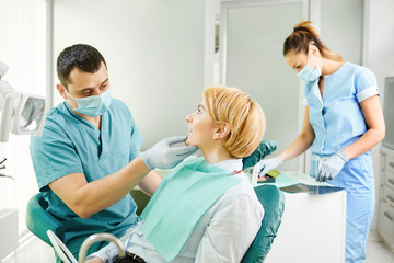 Fototapeta premium Dentist examines the teeth of the patient girl