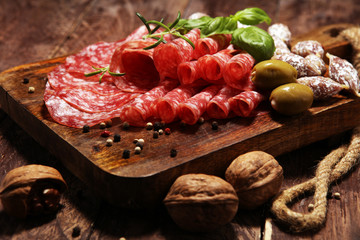 thinly sliced salami on a wooden texture on the background.
