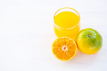 Tangerine orange fruit and juice on white table
