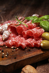 thinly sliced salami on a wooden texture on the background.