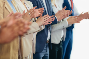 Group of businesspeople clapping in office.