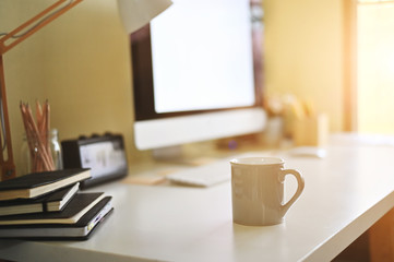 Mug of coffee on creative desk.