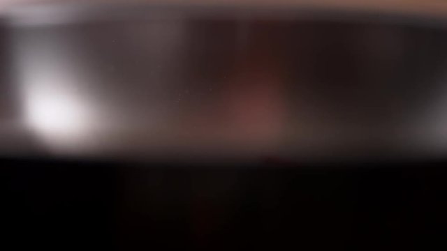 Camera follows adding chopped garlic on cooked bacon in a pan. Shot with high speed camera, phantom flex 4K. Slow Motion.