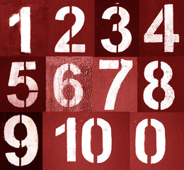 Numbers 0 to 10 in stencil on metal wall in red tone