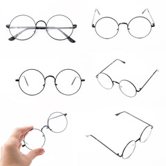 Set of round black-rimmed glasses are view from above. Hand holds glasses. Isolated on a light...
