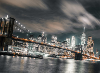 Fototapeta na wymiar long exposure wispy clouds dominate the brooklyn bridge and downtown Manhattan