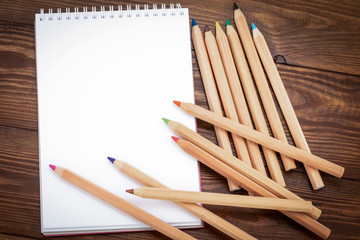 Blank notepad and pencil color on wooden blackground