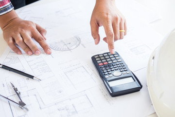 Close-up Of Person's engineer Hand Drawing Plan On Blue Print with architect equipment, Architects discussing at the table, team work and work flow construction concept