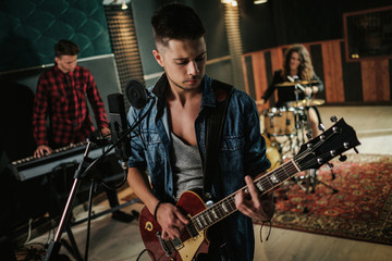 Music band having rehearsal in a studio