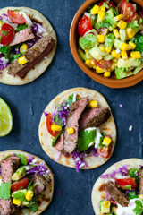Beef steak tortillas with avocado, sweet corn, tomato salsa and red cabbage