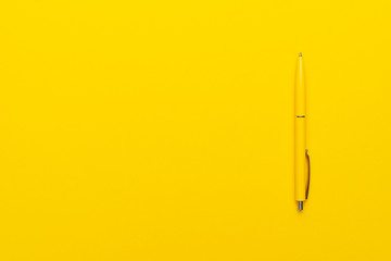 yeloow ballpoint pen on the yellow background with copy space