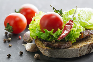 Vegetables. Close-up of lettuce, tomatoes, bread, roast beef, garlic and spices.