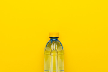 plastic water bottle with yellow cap on the yellow background