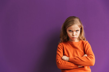 Cute upset little girl standing isolated over violet