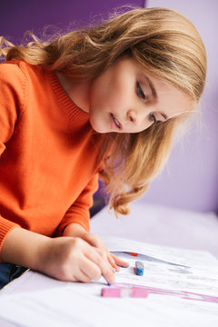 Cute little girl drawing in a coloring book