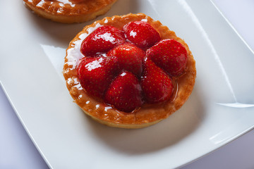 Basket-cake with mascarpone cheese and decorated with strawberry on white plate. High Key. Close up. Selective focus. Top view.