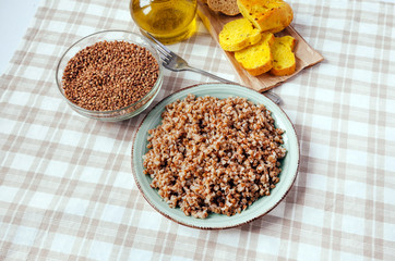 Buckwheat porridge plate bread table yellow brown cereal groats graine cooked boiled oil food