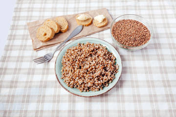 Buckwheat porridge plate bread table yellow brown cereal groats graine cooked boiled oil food