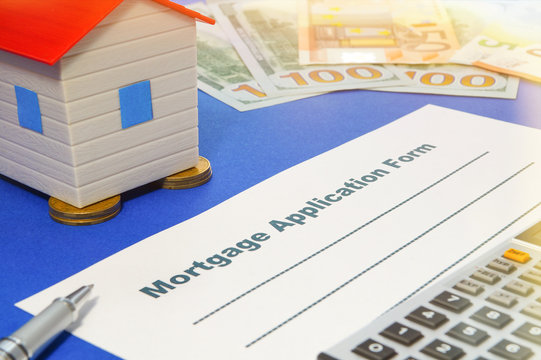 Mortgage application form with a pen and house.