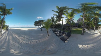 MAURITIUS ISLAND - JUNE 08, 2016: 360 VR video. Ocean skyline and beach with hammock, chaise-longues on tropical resort of Le Morne Brabant, Mauritius. Couple with dog walking along the coast