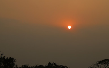Scenery of sunset with heavy smog sky from PM.2.5 air pollution in city. The common environmental problem around the world. 