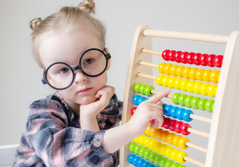 Caucasian little girl with round glasses. Little teacher. Funny glasses humor. Retro style