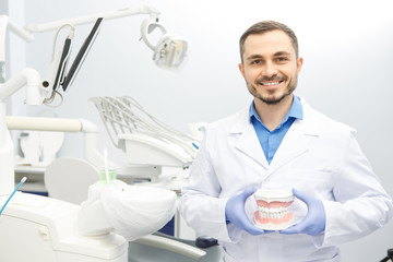 Handsome male professional dentist at his office