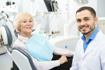 Professional dentist and his senior patient