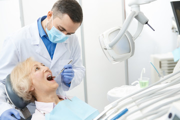 Professional dentist and his senior patient