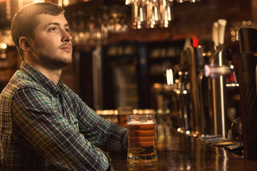Young man relaxing at the pub having beer