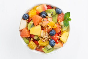 fresh fruit salad on white table, top view