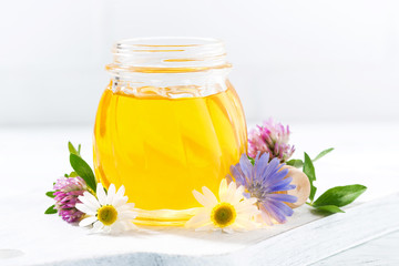 Obraz na płótnie Canvas jar with fresh flower honey on a white table