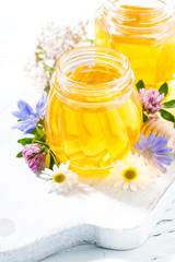 Fototapeta na wymiar jars with fresh flower honey on white background, vertical top view