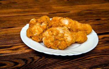 Fried crispy chicken legs on a white plate 