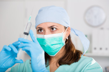 Professional nurse young woman making injection in hospital