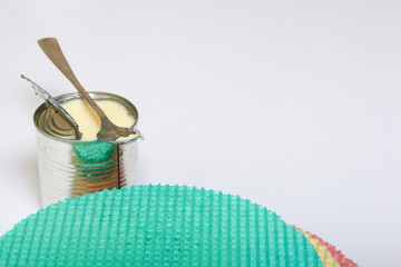 Round wafer cakes of different colors. For making waffle cake. Nearby there is a can of condensed milk to soak the cakes.