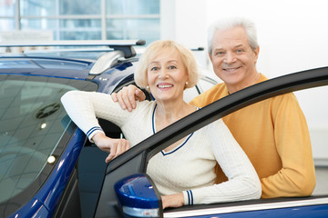 Happy loving senior couple choosing a new car to buy